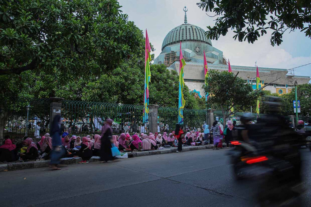 Ribuan umat muslim duduk bersila di trotoar jalan, di pelataran serta di dalam Masjid Raya Jakarta Islamic Center, Koja, Jakarta Utara, Senin, 18 April 2022.