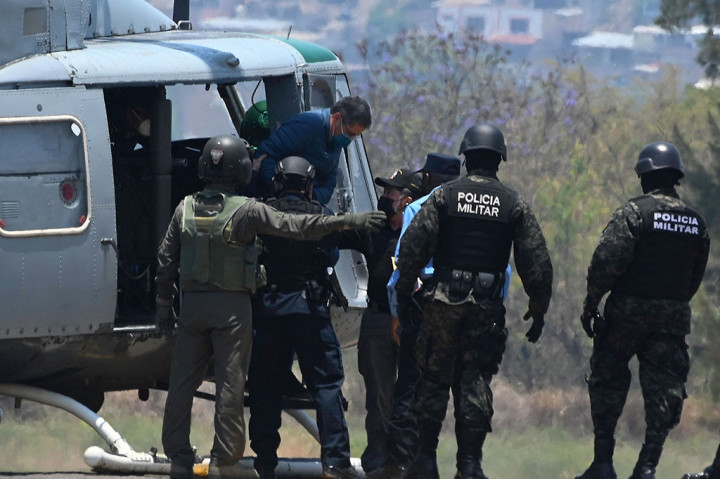 Mantan Presiden Honduras Juan Orlando Hernandez turun dari helikopter setibanya di pangkalan Angkatan Udara di Tegucigalpa, pada 21 April 2022, sebelum diekstradisi ke AS untuk menghadapi tuduhan terkait perdagangan narkoba.
