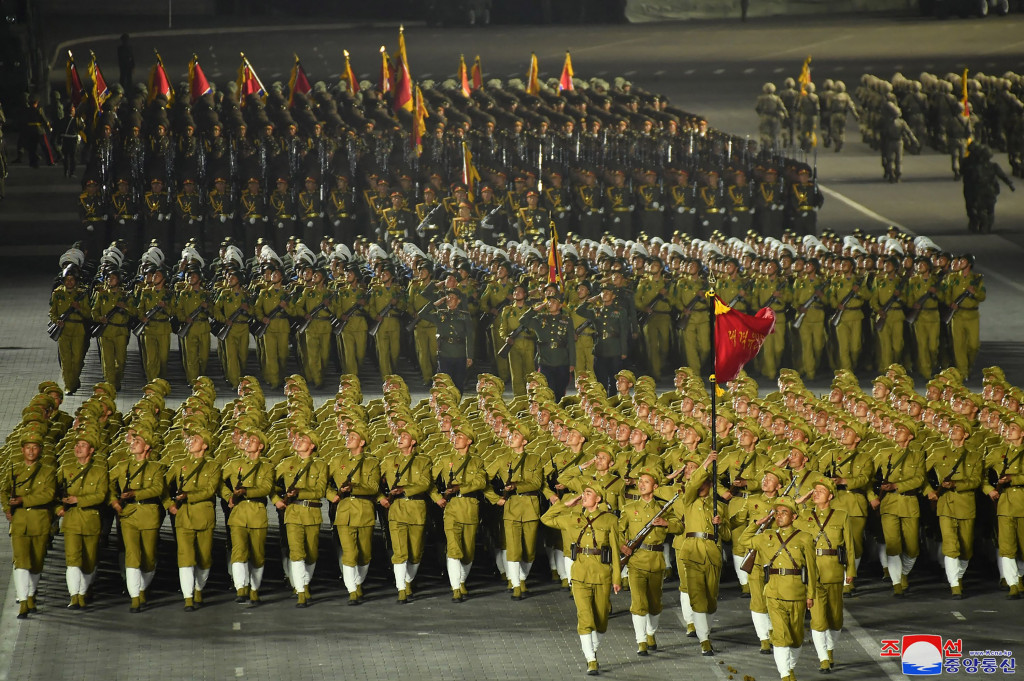 Personel militer berbaris dalam parade militer malam hari untuk memperingati 90 tahun berdirinya Tentara Revolusioner Rakyat Korea di Pyongyang, Korea Utara.