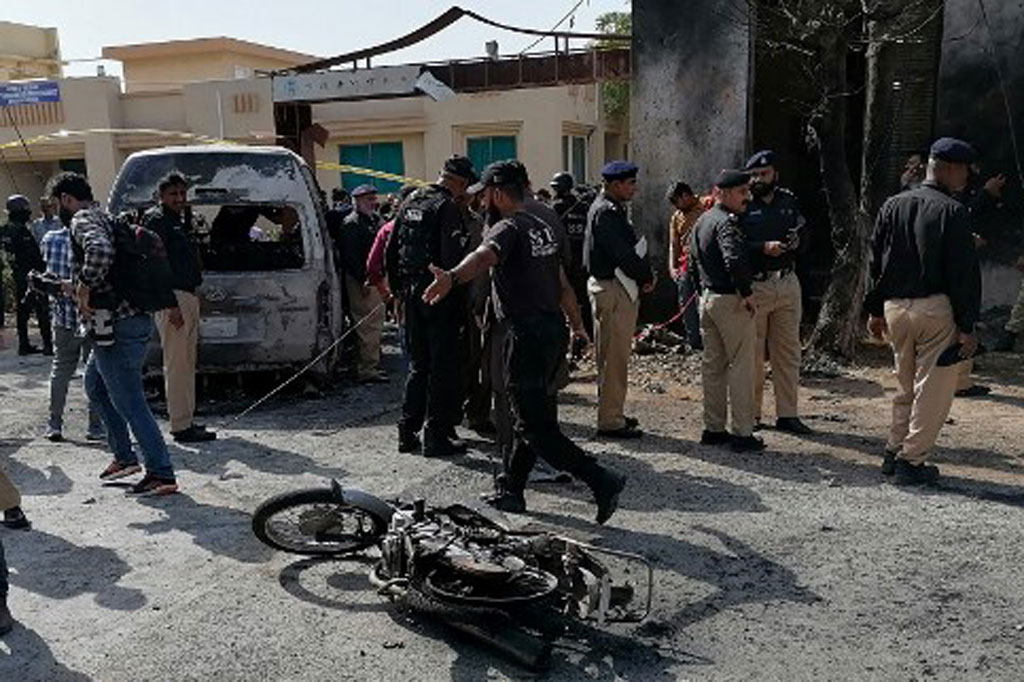 Polisi memeriksa lokasi di sekitar kendaraan yang rusak menyusul bom bunuh diri di dekat Institut Konfusius yang berafiliasi dengan Universitas Karachi, di Karachi, Pakistan, Selasa, 26 April 2022.