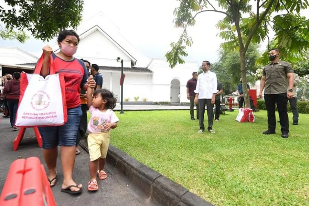 Warga tampak senang setelah mendapatkan paket sembako dari Presiden Jokowi.