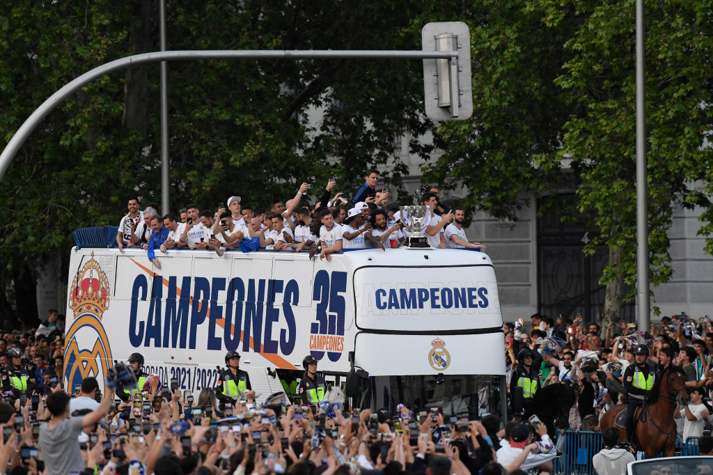 Pemain Real Madrid merayakan kemenangan menjuarai Liga Spanyol atau La Liga musim 2021/2022 dari atas sebuah bus yang berkeliling sambil menyapa para pendukungnya di Cibeles fountain di Kota Madrid, Spanyol, Sabtu, 30 April 2022.