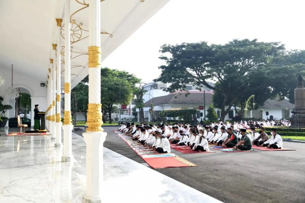 Yogyakarta: Presiden Joko Widodo dan Ibu Iriana Joko Widodo melaksanakan salat Idulfitri 1 Syawal 1443 Hijriah di halaman Gedung Agung, Istana Kepresidenan Yogyakarta, Senin, 2 Mei 2022.
Salat diselenggarakan secara terbatas dan diikuti perangkat kepresidenan, paspampres, dan keluarga pegawai Istana Yogyakarta.
Sekitar pukul 06.28 WIB, Presiden Jokowi beserta Ibu Iriana dan putra bungsunya, Kaesang Pangarep, tampak keluar dari Gedung Agung menuju halaman depan. Presiden langsung menempati saf paling depan, sementara Ibu Iriana menempati tempat yang telah ditentukan bagi jemaah wanita di sebelah kiri.
Tepat pada pukul 06.35 WIB salat Idulfitri pun dimulai. Bertindak selaku imam dan khatib dalam kesempatan tersebut yaitu Masmin Afif yang merupakan Kepala Kantor Wilayah Kementerian Agama Daerah Istimewa Yogyakarta. Sementara itu, bertindak sebagai bilal adalah Abdul Rosyid, pengurus Masjid Darussalam Istana Yogyakarta. Foto: BPMI Setpres