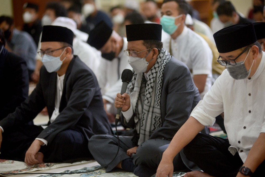 Menteri Koordinator Politik Hukum dan Keamanan (Menkopolhukam) Mahfud MD (tengah) didampingi Direktur Utama Media Indonesia Firdaus Dayat (kanan) dan Ketua Dewan Kemakmuran Masjid (DKM) Ade Alawi bertakbir sebelum menjalankan salat Idulfitri di Masjid Nursiah Daud Paloh, Jakarta, Senin, 2 Mei 2022.