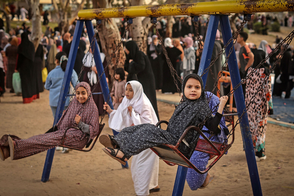 Anak-anak Muslim Palestina bermain usai salat Idulfitri pagi, menandai berakhirnya bulan suci Ramadan di Kota Gaza pada 2 Mei 2022.