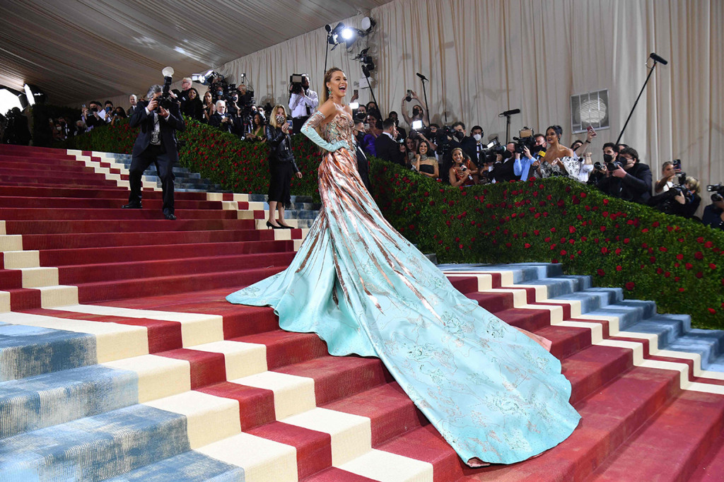 Blake Lively. Bintang The Gossip Girl ini tak hanya hadir sebagai undangan, namun ia juga didaulat untuk co-hosting Met Gala 2022. Ia tampil dalam balutan gaun tembaga dari Versace dengan ekor panjang dan melilit.