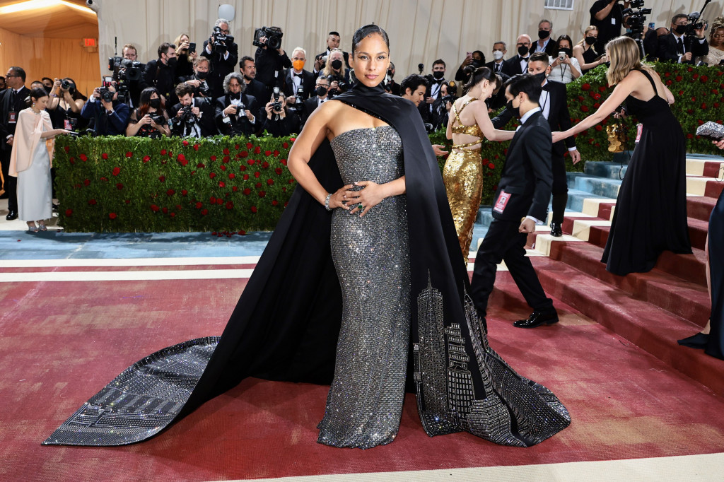 Penyanyi Alicia Keys mengenakan gaun perak dan jubah hitam oleh Ralph Lauren. Jubah hitam tersebut disulam berbentuk cakrawala Kota New York.