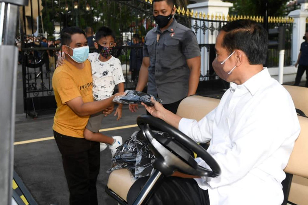 Presiden Joko Widodo membagikan kaus kepada warga.