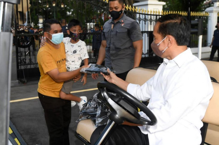 Presiden Joko Widodo membagikan kaus kepada warga.