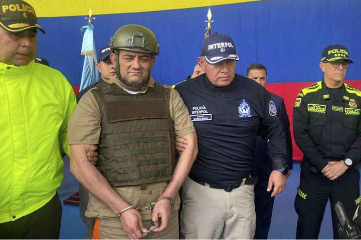 Anggota polisi nasional Kolombia mengawal raja obat bius Kolombia dan kepala Klan Teluk, Dairo Antonio Usuga -alias 'Otoniel' (kedua kiri), saat proses ekstradisi ke AS, di Bogota pada Rabu, 4 Mei 2022.