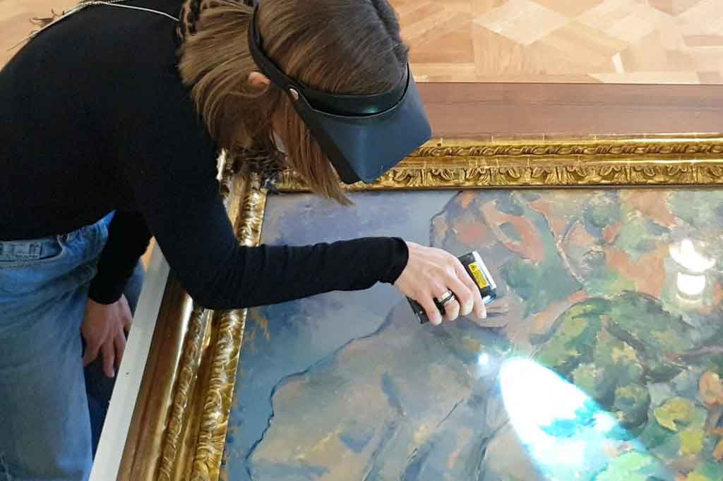 Seorang spesialis museum memeriksa lukisan karya seniman Prancis Paul Cezanne berjudul 'Paysage, Montagne Sainte-Victoire' setelah kembalinya karya seni dari Koleksi Morozov tersebut dari sebuah pameran di Paris.