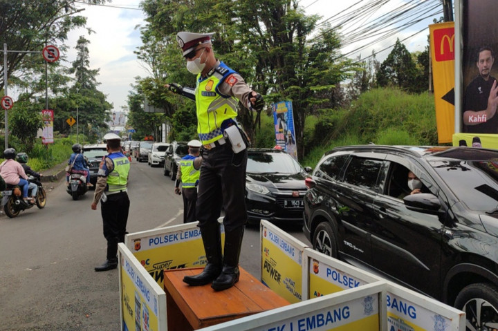 Aksi sejumlah anggota Sabhara Polres Cimahi menyita perhatian para pengguna kendaraan yang hendak meninggalkan kawasan Lembang, Kabupaten Bandung Barat, Minggu, 8 Mei 2022.