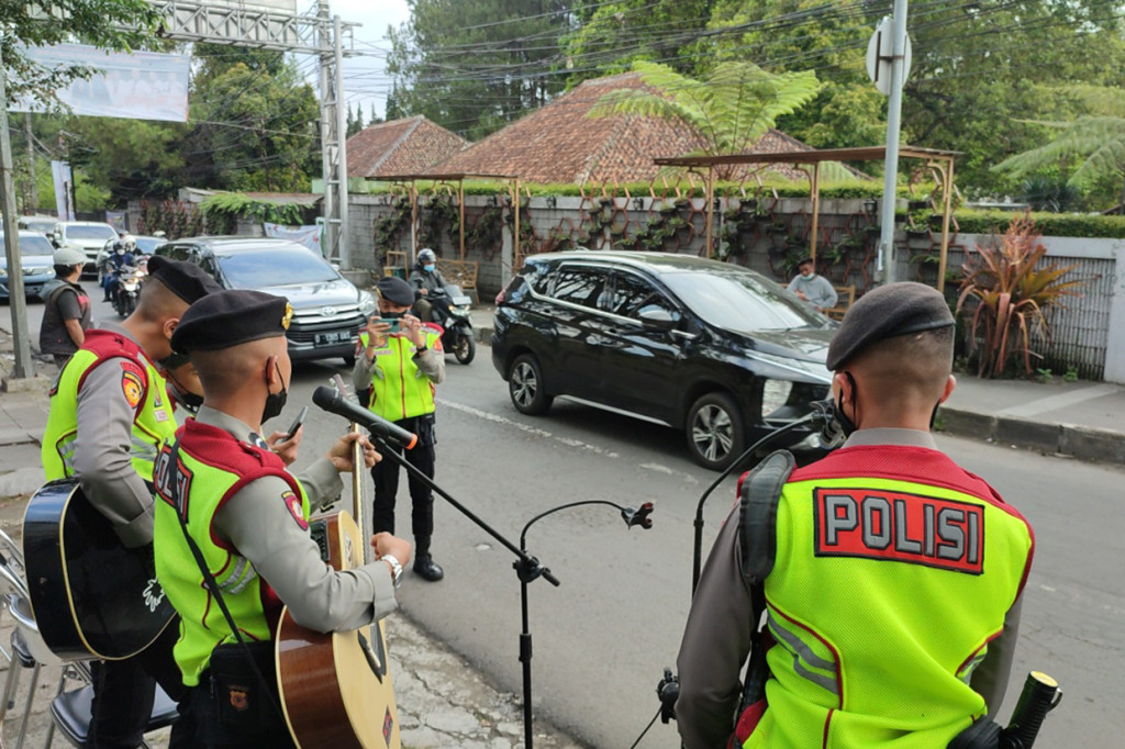 Aksi para pengamen jalanan dadakan ini dilakukan disela-sela rutinitas anggota polisi mengatur lalulintas arus balik libur lebaran di kawasan wisata ini.