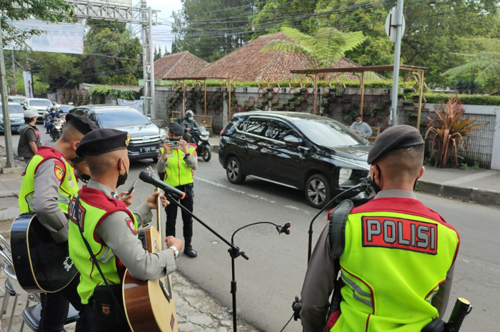 Aksi para pengamen jalanan dadakan ini dilakukan disela-sela rutinitas anggota polisi mengatur lalulintas arus balik libur lebaran di kawasan wisata ini.