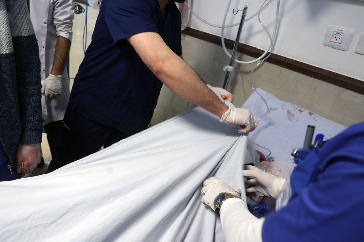 Seorang petugas medis menutupi tubuh jurnalis veteran Al Jazeera Shireen Abu Aqleh, yang ditembak mati oleh pasukan Israel saat meliput penggerebekan di kamp pengungsi Jenin di Tepi Barat pada 11 Mei 2022, di rumah sakit di Jenin.