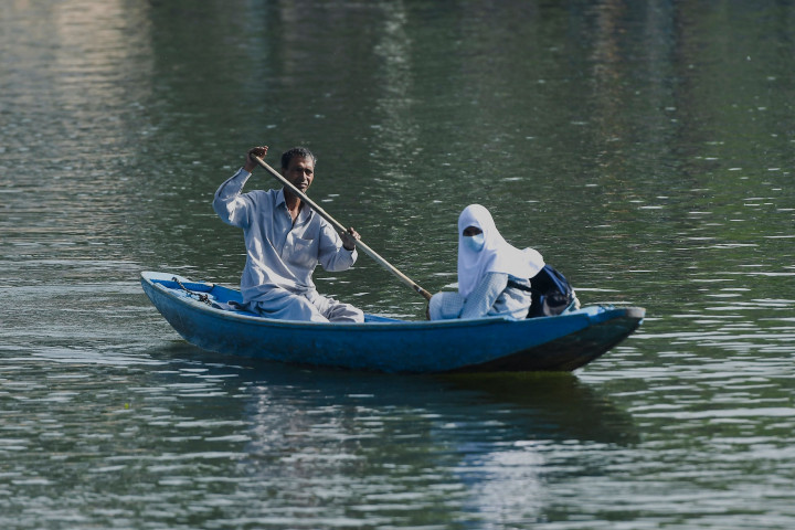 Seorang pria mendayung perahu kecil selama jam sekolah di Danau Dal di Srinagar, India, Rabu, 11 Mei 2022.