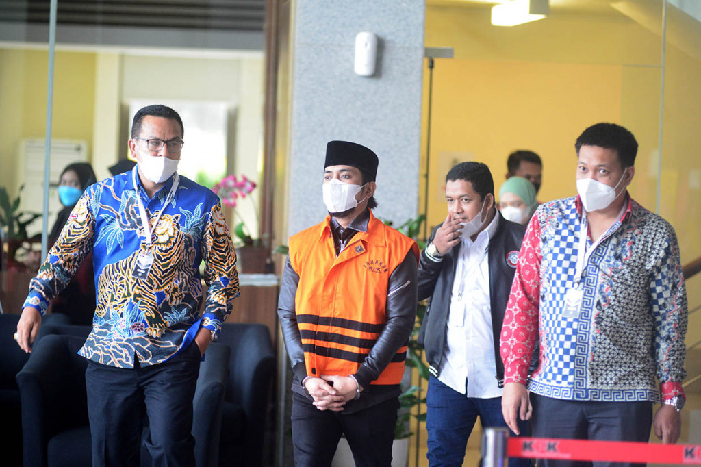 Tersangka Bupati non aktif Penajam Paser Utara (PPU) Abdul Gafur Mas'ud (tengah) dan tersangka mantan Bendahara DPC Partai Demokrat Balikpapan Nurafifah Balqis (belakang) berjalan keluar seusai menjalani pemeriksaan di Gedung Komisi Pemberantasan Korupsi (KPK), Rasuna Said, Jakarta, Kamis, 12 Mei 2022.