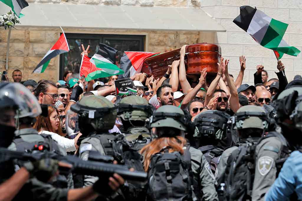 Puluhan warga Palestina yang mengerumuni peti Akleh berjalan menuju gerbang Rumah Sakit St. Joseph. Beberapa dari mereka melambai-lambaikan bendera Palestina dan berteriak 'dengan jiwa dan darah kami, kami akan menebusmu Shireen'.