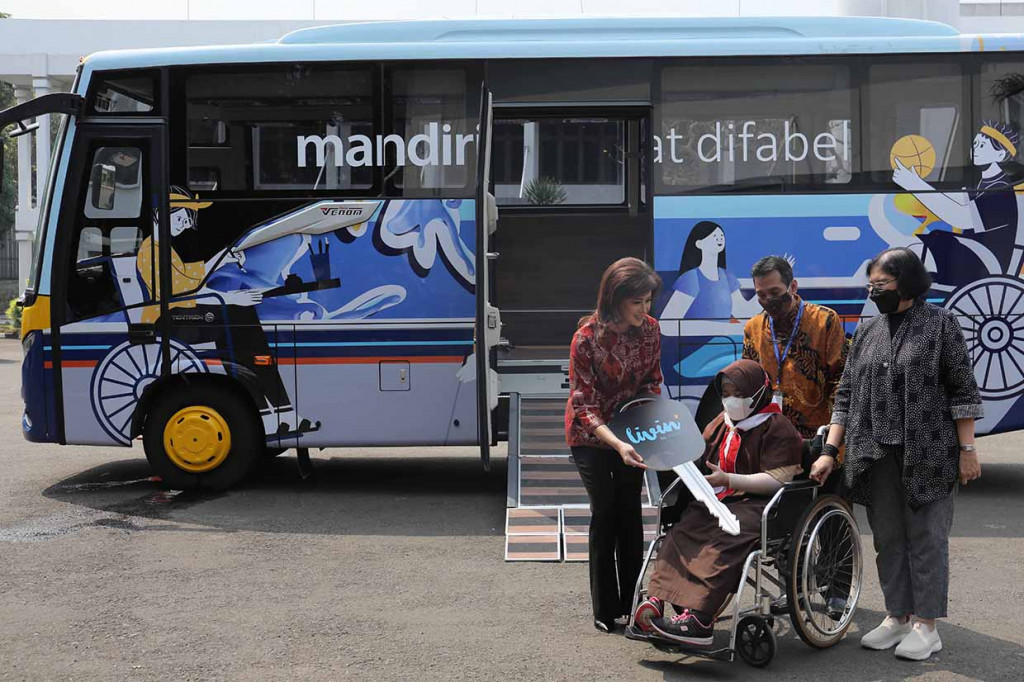 Ketua Yayasan Pembinaan Anak Cacat (YPAC) Jakarta Kumala Insiwi Suryo (kiri) dan Wadirut Bank Mandiri Alexandra Askandar menyerahkan secara simbolis kepada siswi YPAC Jakarta kunci bis khusus disabilitas di YPAC Jakarta, Rabu, 18 Mei 2022.