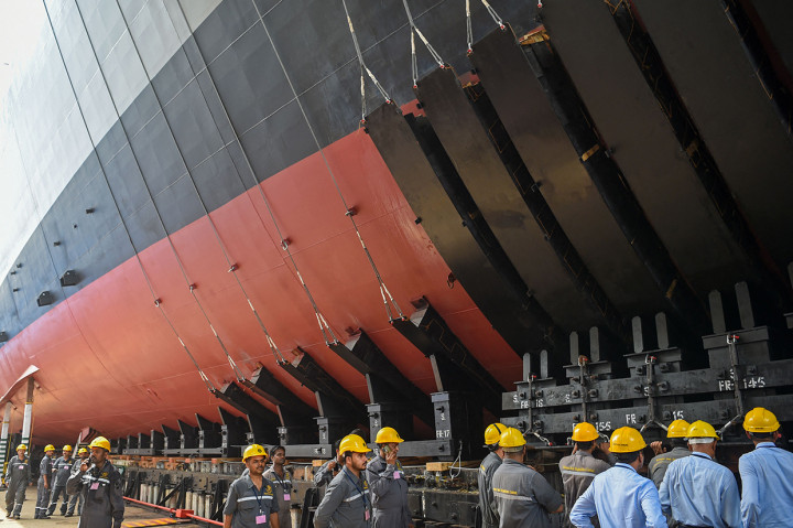 Pekerja memeriksa bagian lambung kapal sebelum peluncuran kapal memasuki air dari Mazagaon Dock Shipbuilders Limited (MDL), di Mumbai, Selasa, 17 Mei 2022.