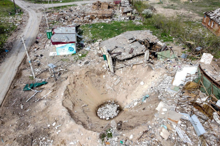 Pemandangan dari udara menunjukkan kawah dan rumah yang hancur di desa Yatskivka, Ukraina timur.