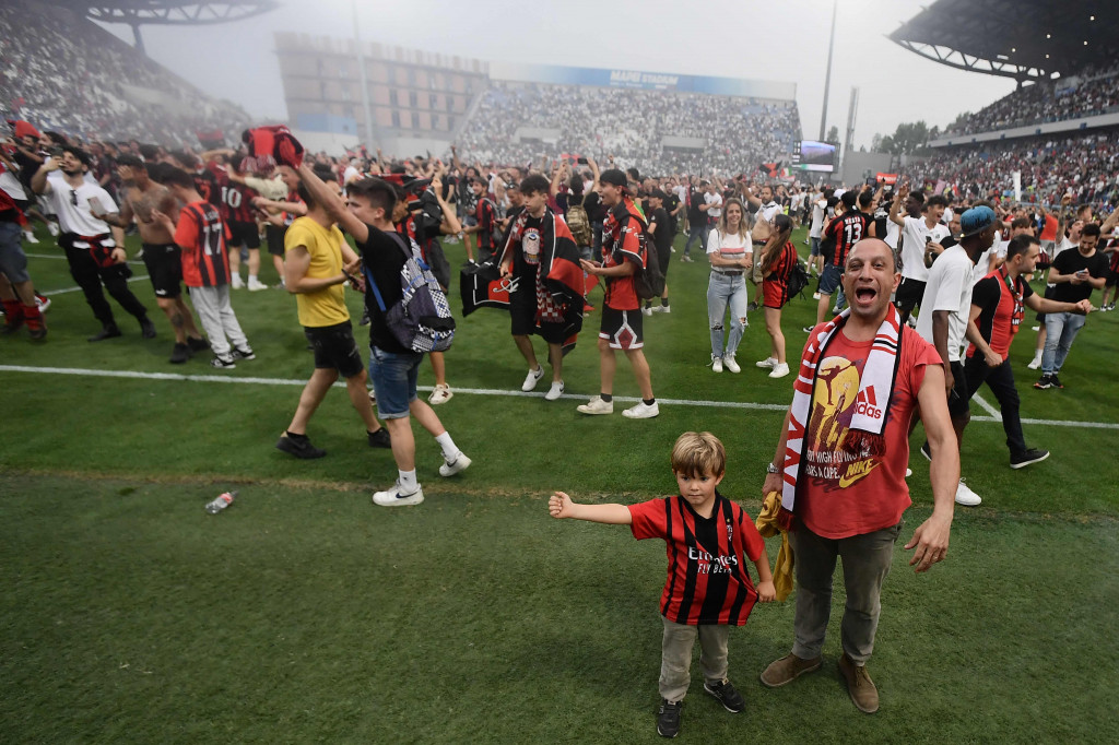 Fans turun ke lapangan untuk merayakan kemenangan AC Milan dalam pertandingan sepak bola Serie A Italia antara Sassuolo dan AC Milan.