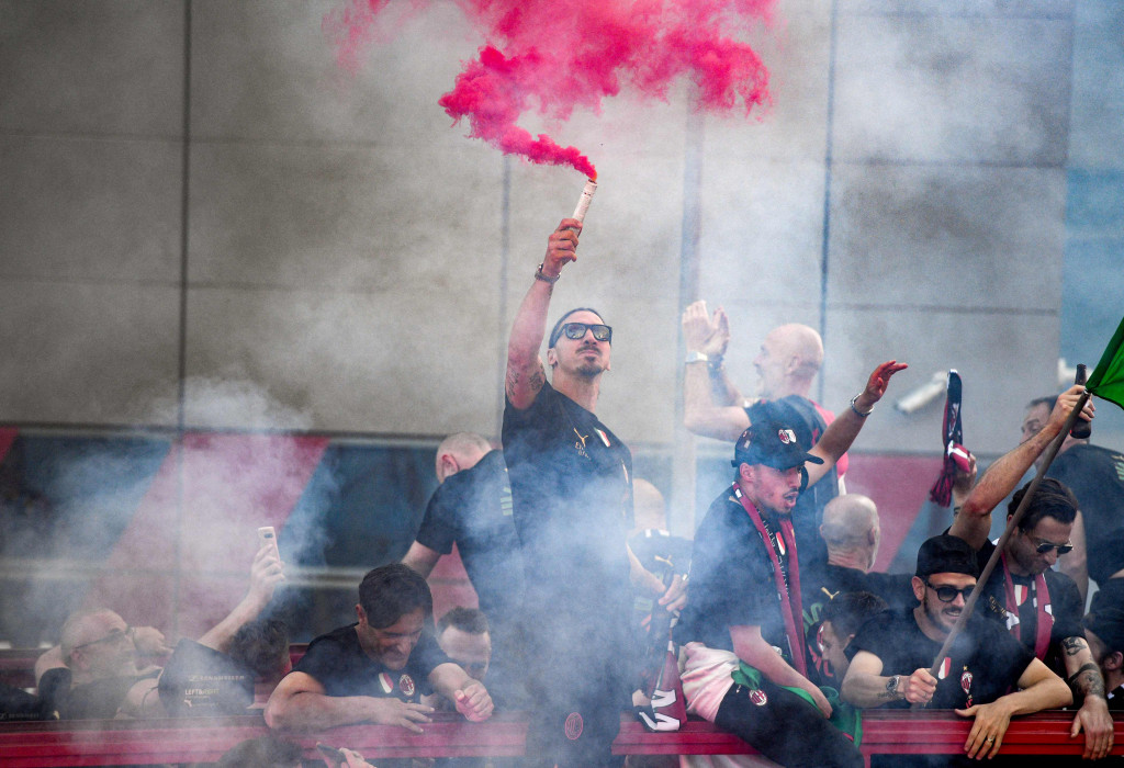 Bintang AC Milan, Zlatan Ibrahimovic, tampak memegang flare berwarna merah.