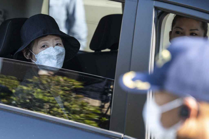 Shigenobu meninggalkan penjara di Tokyo dengan mobil hitam bersama putrinya, sementara beberapa pendukungnya memegang spanduk bertuliskan