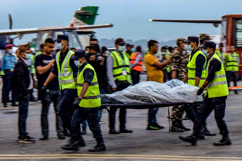 Personel keamanan Nepal mengevakuasi jenazah korban kecelakaan pesawat Twin Otter yang dioperasikan Tara Air yang jatuh sebelumnya di Himalaya dengan 22 orang di dalamnya, di Bandara Internasional Tribhuvan di Kathmandu pada Senin, 30 Mei 2022.