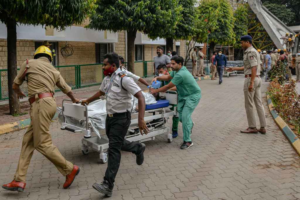 Petugas pemadam kebakaran dan layanan darurat memindahkan para pekerja ke rumah sakit. 