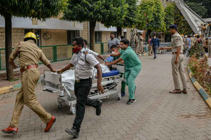 Petugas pemadam kebakaran dan layanan darurat memindahkan para pekerja ke rumah sakit. 