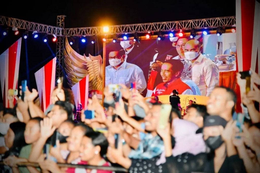 Dengan mengenakan jaket berwarna merah berlogo G20, Jokowi hadir di stadion sekira pukul 21.25 WITA. Ia beserta Iriana menyapa masyarakat yang hadir, sembari berjalan memasuki Stadion Marilonga.