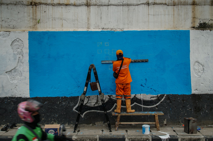 Pekerja menyelesaikan pembuatan mural di kawasan Ancol, Jakarta, Senin, 6 Juni 2022. 