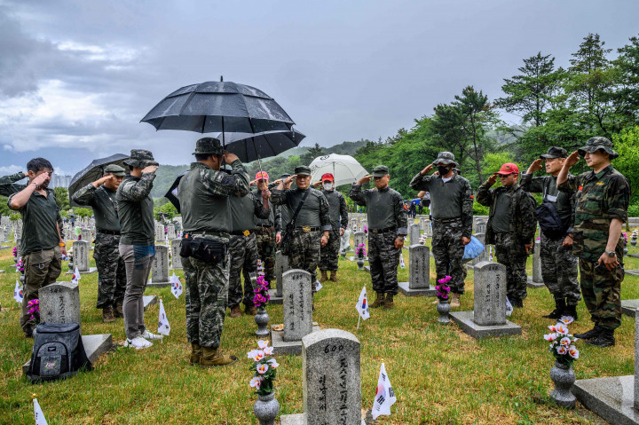 Para veteran memberi hormat di depan kuburan untuk memberikan penghormatan mereka di Pemakaman Nasional saat Korea Selatan menandai Hari Peringatan, yang menghormati mereka yang tewas selama Perang Korea 1950-53 dan dalam operasi lain saat melayani negara mereka, di Seoul pada 6 Juni 2022.