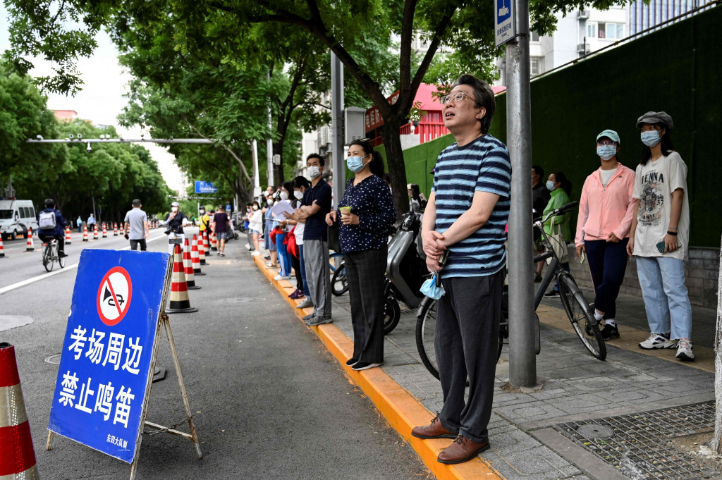 Orang tua menunggu di luar sekolah saat para siswa mengikuti hari pertama Ujian Masuk Perguruan Tinggi Nasional (NCEE), yang dikenal sebagai “gaokao”, di Wuhan, di provinsi Hubei pada 7 Juni 2022.
