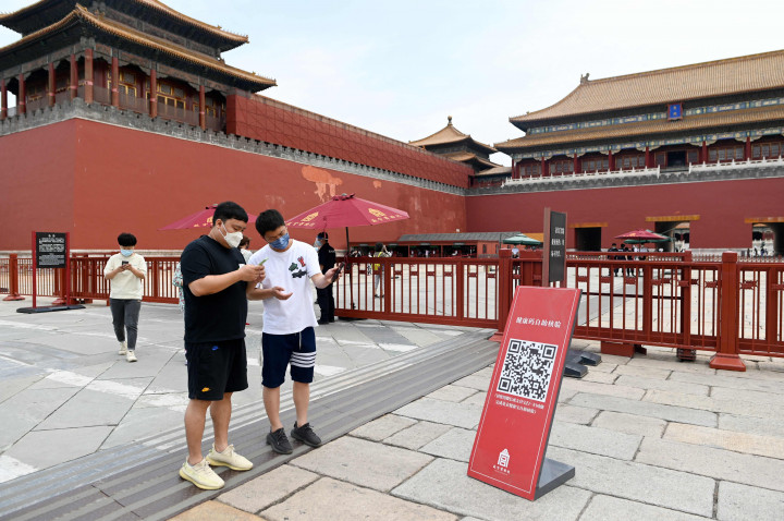 Orang-orang menggunakan ponsel untuk memindai kode kesehatan di pintu masuk Kota Terlarang di Beijing sebelum kunjungan mereka setelah pemerintah melonggarkan beberapa pembatasan Covid-19, Selasa, 7 Juni 2022.