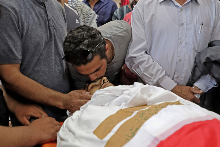 Seorang pelayat mencium dahi Mahmud Fayez Abu Ayhour Palestina, 27, selama pemakamannya di Halhul, utara kota Hebron, Tepi Barat, pada Kamis, 9 Juni 2022.