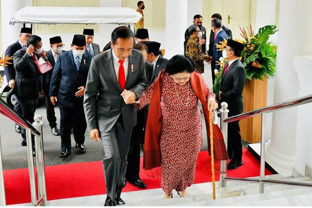 Jokowi menggandeng Megawati Soekarnoputri saat menaiki tangga Istana Negara Jakarta.