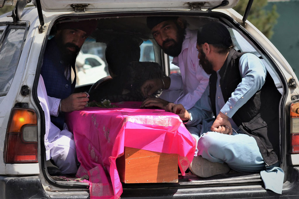 Warga membawa peti berisi jenazah korban serangan oleh orang-orang bersenjata di sebuah kuil Sikh di Kabul, Afghansistan pada Sabtu, 18 Juni 2022.