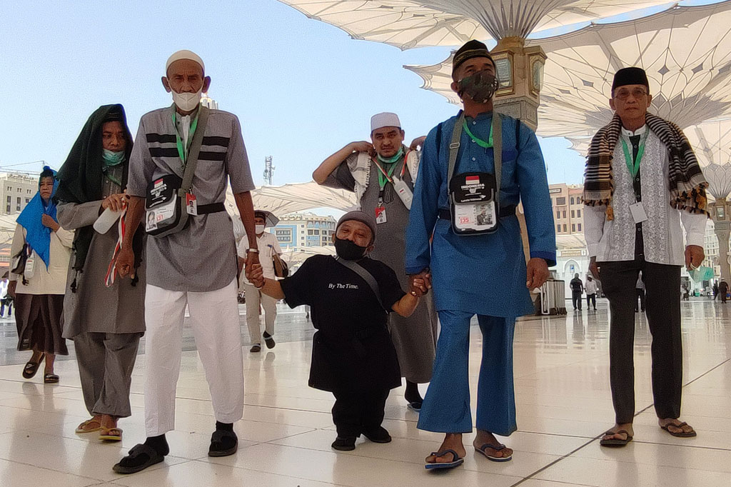 Sudirman, jemaah calon  haji difabel dibantu teman satu kamar saat akan menjalankan salat Dzuhur di Masjid Nabawi, Madinah, Arab Saudi, Sabtu, 18 Juni 2022.