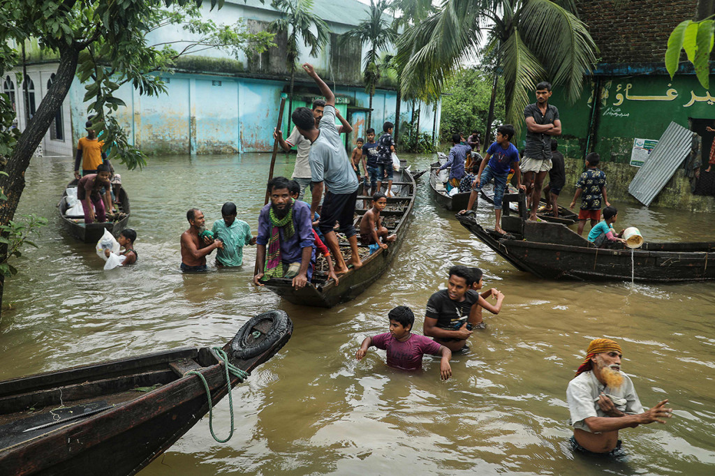 Orang-orang berkumpul untuk mengumpulkan bantuan makanan di daerah pemukiman yang terendam banjir menyusul hujan deras monsun di Companiganj pada 20 Juni 2022.