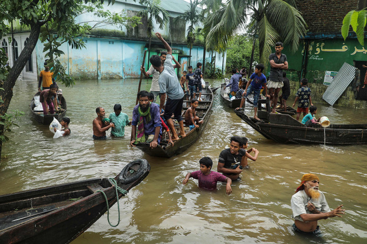 Orang-orang berkumpul untuk mengumpulkan bantuan makanan di daerah pemukiman yang terendam banjir menyusul hujan deras monsun di Companiganj pada 20 Juni 2022.