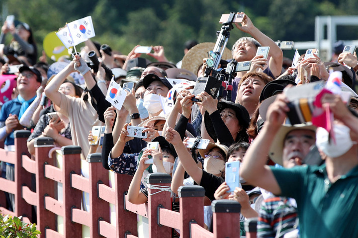 Orang-orang menyaksikan roket luar angkasa buatan Korea Selatan Nuri diluncurkan dari Pusat Antariksa Naro di desa pesisir selatan Goheung pada 21 Juni 2022, dalam upaya kedua untuk menempatkan satelit ke orbit setelah peluncuran Oktober lalu gagal.