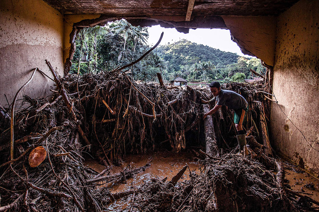 Warga mencari barang-barang miliknya yang tersisa di puing-puing rumah yang rusak akibat diterjang banjir bandang di Desa Purasari, Leuwiliang, Bogor, Jumat, 24 Juni 2022. 