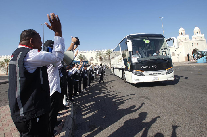 Petugas Panitia Penyelenggara Ibadah Haji (PPIH) melambaikan tangan ke arah bus yang membawa jemaah haji Indonesia terakhir yang akan menuju Mekkah usai melakukan niat ihram di Masjid Bir Ali, Madinah, Arab Saudi, Senin, 27 Juni 2022.