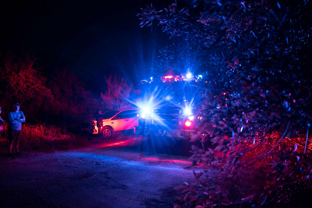 Sebuah truk pemadam kebakaran berjalan menuju lokasi di mana sebuah traktor-trailer ditemukan dengan para migran di dalam di luar San Antonio, Texas pada 27 Juni 2022. 