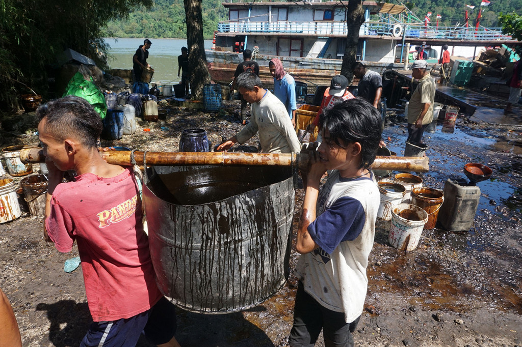 Nelayan dan warga mengumpulkan tumpahan minyak mentah yang menggenangi perairan sekitar Dermaga Wijayapura dan Area 70 Cilacap, Jateng, Selasa, 28 Juni 2022.