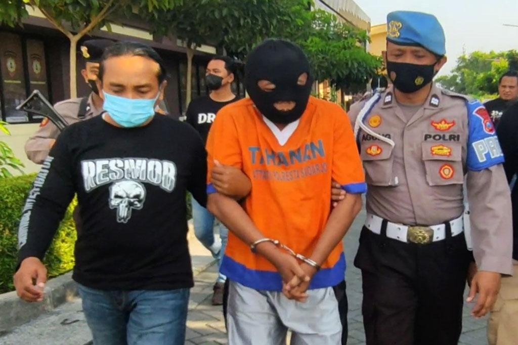 Polisi menggiring J, tersangka penembakan juragan rongsokan saat konferensi pers di Mapolresta Sidoarjo, Jumat, 1 Juli 2022. J diringkus polisi pada Rabu, 29 Juni 2022 dini hari di kawasan Sokobanah, Sampang.