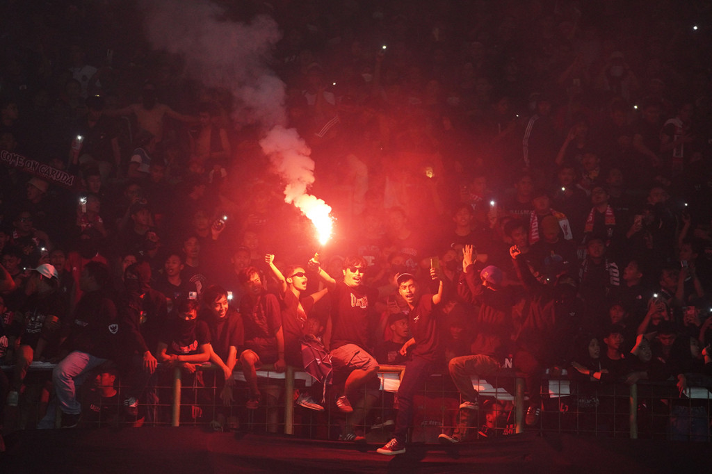 Imbas dari penyalaan belasan flare itu menjadikan stadion dipenuhi asap. 