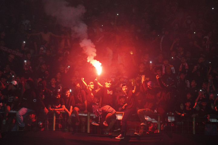 Imbas dari penyalaan belasan flare itu menjadikan stadion dipenuhi asap. 